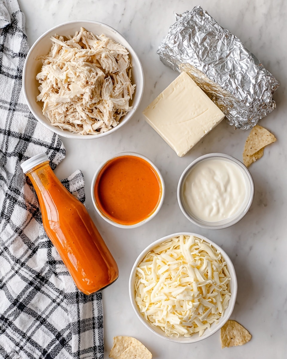 The image shows a flat lay of cooking ingredients on a white marbled surface with a white and black checkered cloth to the side. There is a white bowl filled with light tan shredded chicken at the top left, next to two blocks of cream cheese partially wrapped in silver foil on the right. Below the chicken bowl is a clear glass bottle of bright orange buffalo sauce. To the right of the bottle is a small white bowl with creamy white ranch dressing. At the bottom right is another white bowl filled with off-white shredded cheese. There are light yellow tortilla chips partially visible on the top left and bottom right edges. photo taken with an iphone --ar 4:5 --v 7