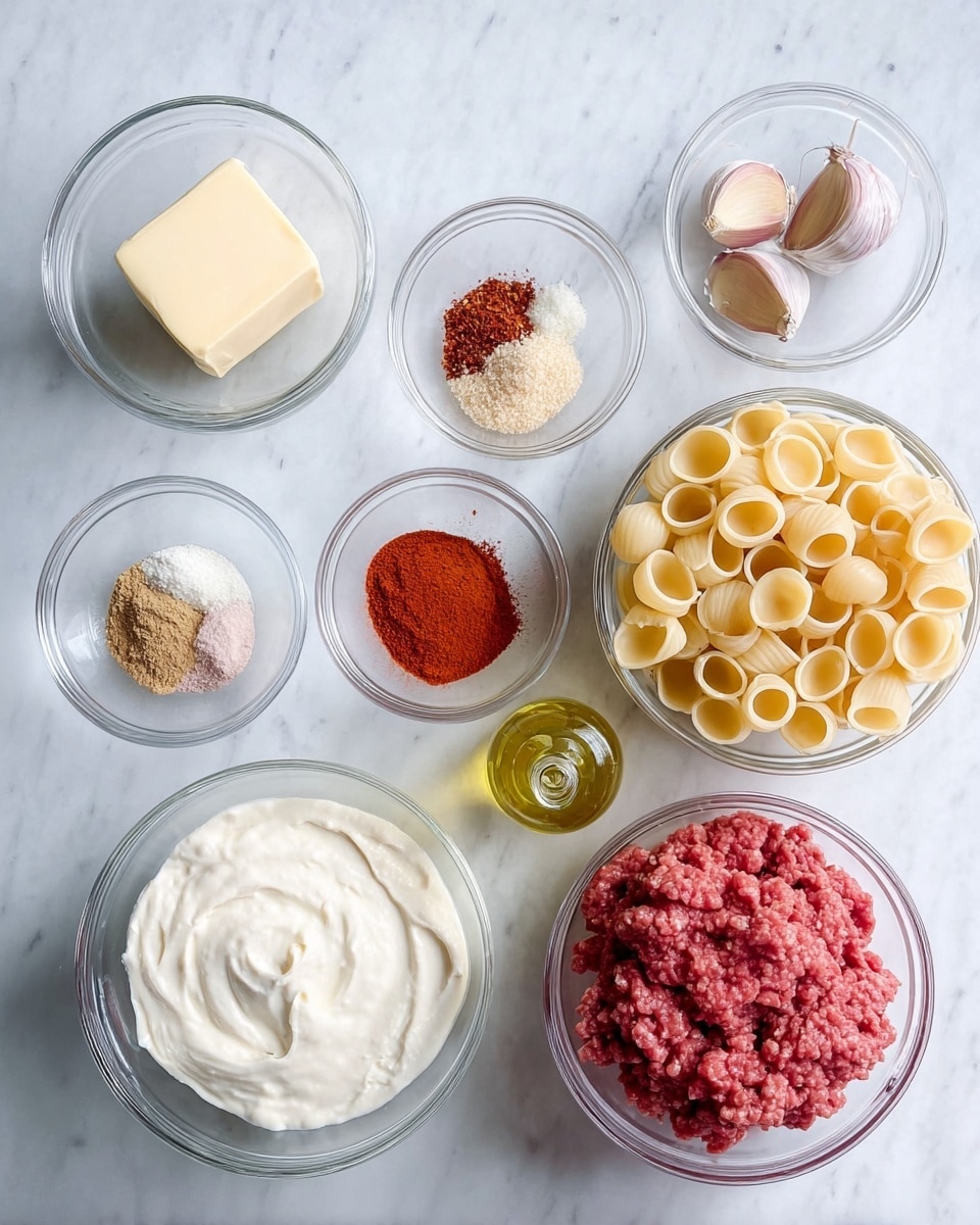 The image shows a top view of various cooking ingredients arranged neatly on a white marbled surface. There are nine clear glass bowls: one with a block of butter, one with two cloves of garlic, one with a mix of red and white spices, one with a single onion, one with bright red spice powder, one filled with round, uncooked pasta shells, one large bowl with white yogurt or sour cream, and a large bowl with raw ground meat. A small glass bottle with olive oil is also included, positioned near the bowls. Everything is displayed clearly with natural light, making textures and colors vivid. photo taken with an iphone --ar 4:5 --v 7