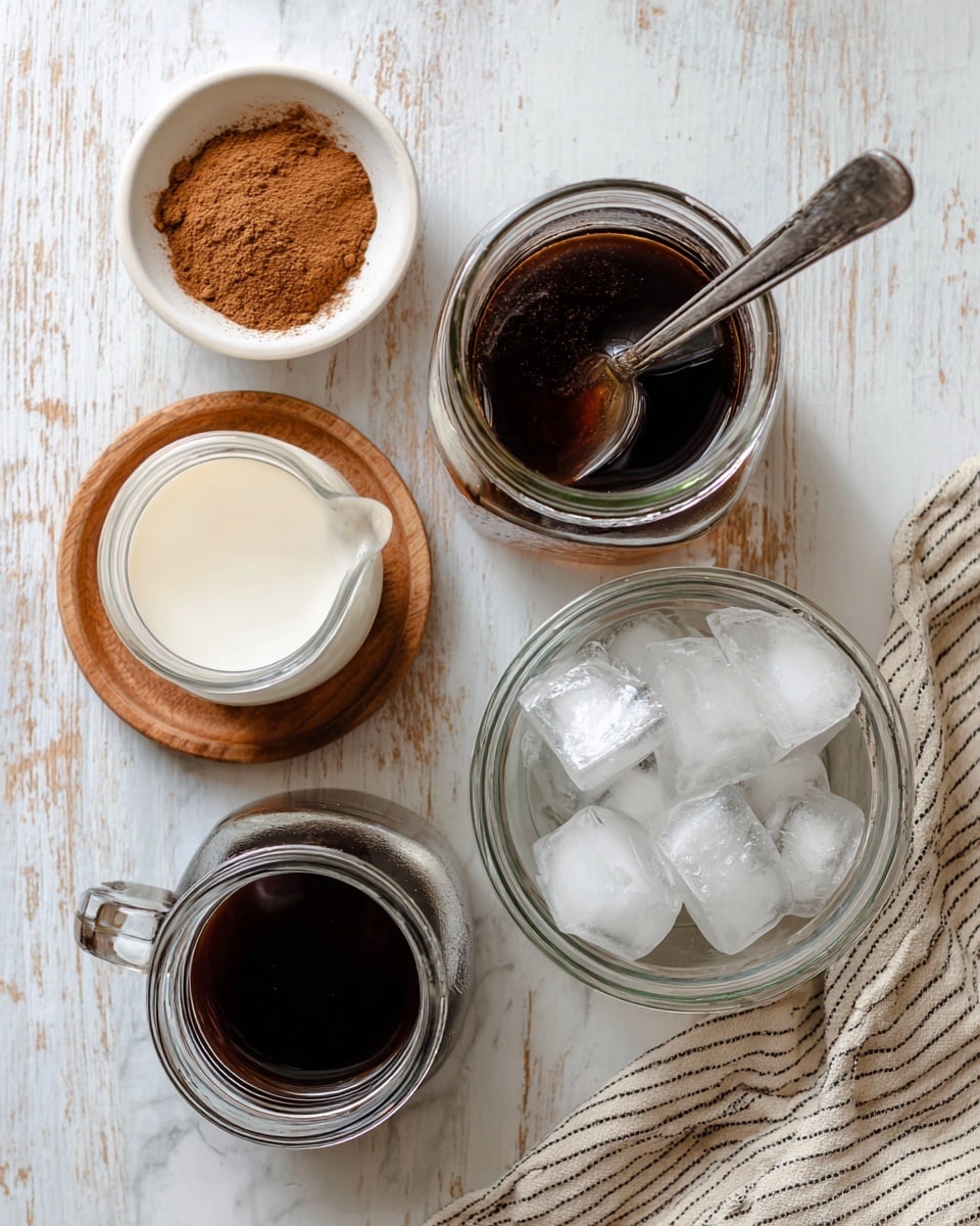 The image shows five different containers on a white marbled surface with a wooden texture under them. There is a small white bowl with brown cinnamon powder on the top left. Near the center, a clear glass jar holds dark brown syrup with a silver spoon inside. Below and to the left, a glass measuring cup contains white milk. Next to it on the right, a clear glass jar is filled with ice cubes. At the bottom left, a glass jar holds dark brewed coffee. A beige and white striped cloth is partly visible on the bottom right. Photo taken with an iphone --ar 4:5 --v 7