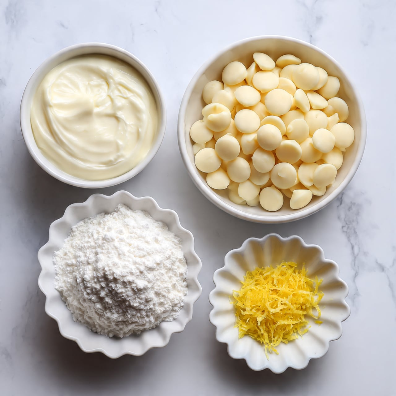 A top view shows four small white bowls with different ingredients on a white marbled surface. The largest bowl on the top right is filled with many round, smooth, pale ivory white chocolate chips. To the left, a smaller white bowl holds a thick layer of white heavy cream with a smooth surface. Below, centered, a white scalloped bowl contains a fluffy pile of white confectioners' sugar. On the right side of the sugar bowl is a tiny white scalloped cup filled with bright yellow lemon zest, finely grated and textured. The arrangement is neat and evenly spaced. Photo taken with an iphone --ar 4:5 --v 7