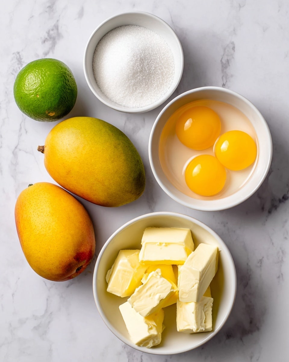 The image shows the ingredients for a recipe arranged on a white marbled surface. There are two yellow-orange mangoes placed side by side at the bottom left. Above them, a whole green lime is placed near the top left. In the center, a small white bowl filled with white sugar is visible. To the right, a white bowl holds four bright yellow egg yolks. Below that, another white bowl contains several pieces of yellow butter. Each ingredient is clearly separated, creating a neat and colorful display. Photo taken with an iphone --ar 4:5 --v 7